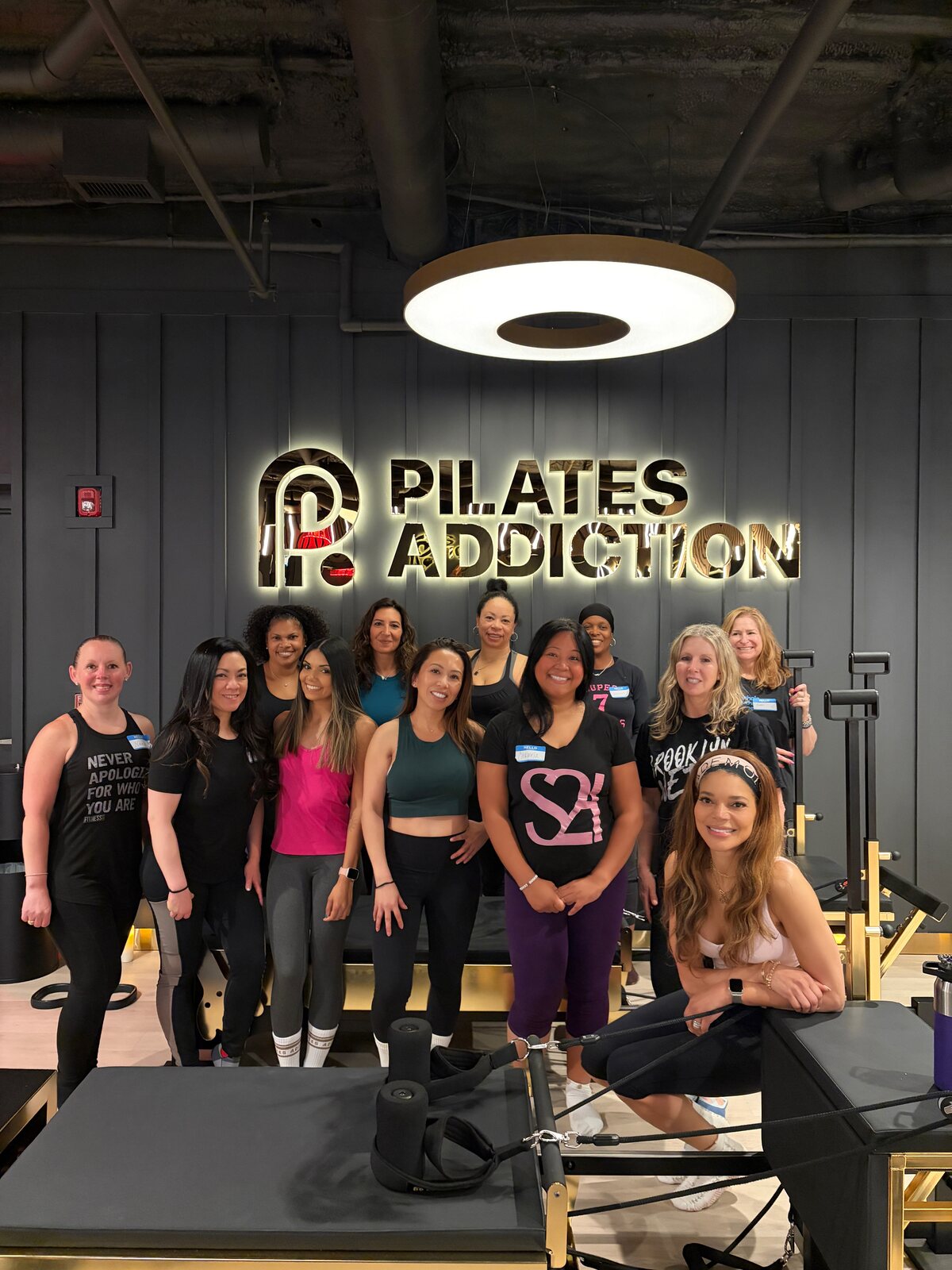 Nikki Jones with a group class under the Pilates Addiction sign in Short Hills